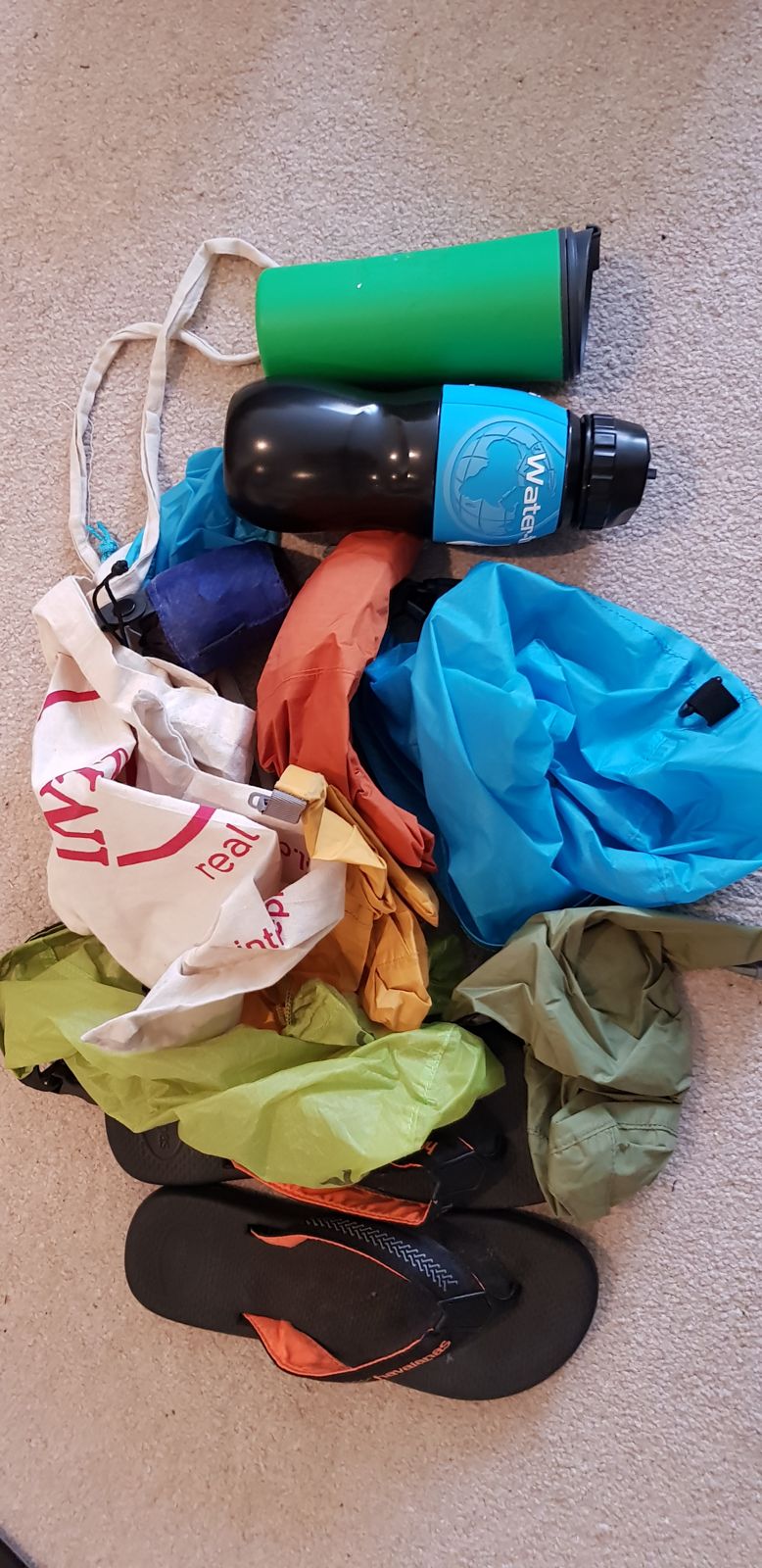 A filter water bottle, an insulated mug, dry bags and flip-flops