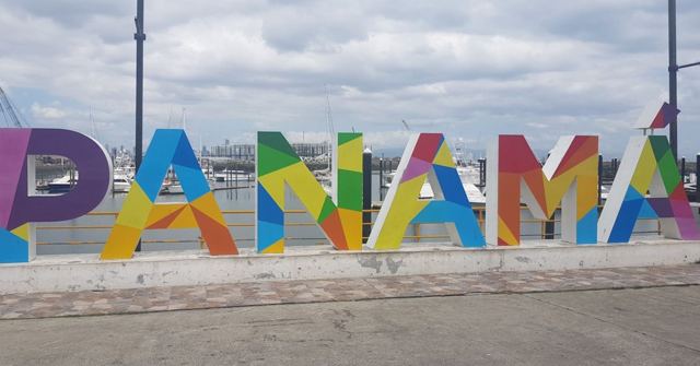 Large multicoloured letters spelling Panama with city buildings behind.