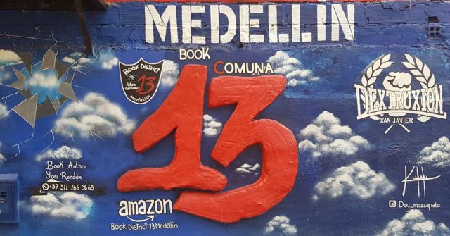A blue mural with clouds, a big red 13 and the word Medellin.