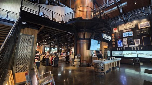 Interior of a distillery visitor centre with a tall copper column still and exhibits.