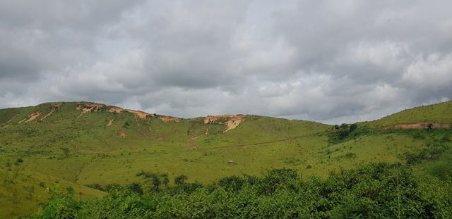 Green hills under a cloudy sky on the road through the DRC.