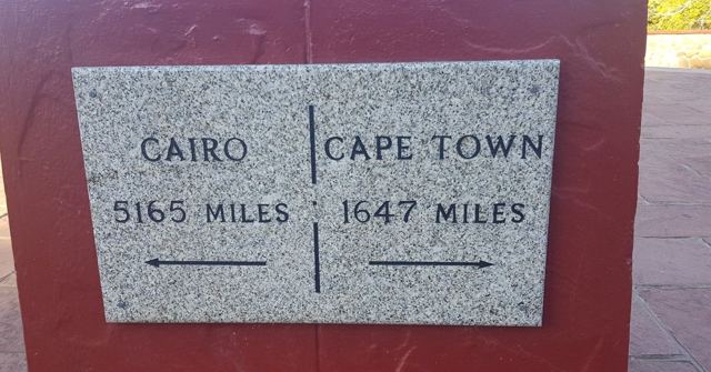 A stone marker showing Cairo 5165 miles and Cape Town 1647 miles in opposite directions.