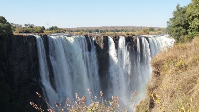 Victoria Falls pouring into a deep gorge with spray rising.