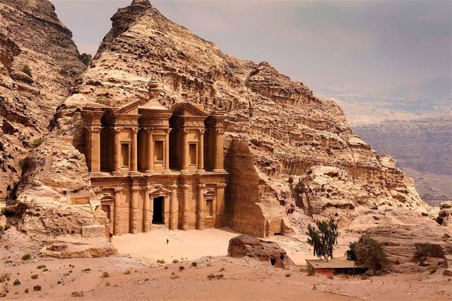 The huge carved facade of the Monastery set into a rocky sandstone mountainside at Petra.