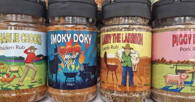 A row of barbecue rub jars with cartoon labels including Charlie Chook, Smoky Doky and Larry the Lamb.