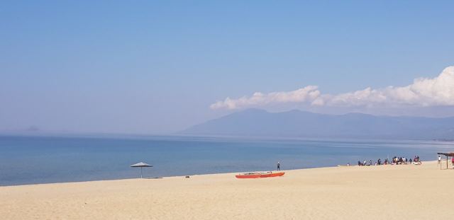 Golden sand and calm blue water on the shore of Lake Malawi.