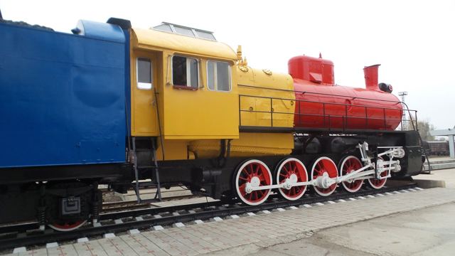 A brightly painted blue, yellow and red steam locomotive on display in Chisinau.