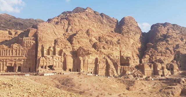 Ornate tomb facades carved into rugged red sandstone cliffs at Petra.
