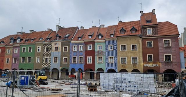 A row of narrow, brightly coloured historic townhouses on Poznań's Old Market Square.