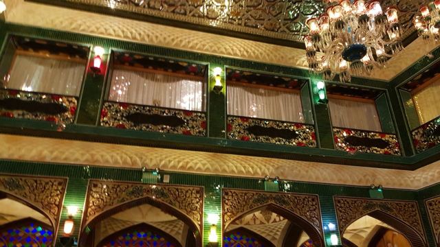 An ornate hotel atrium in Souq Waqif, lit by chandeliers.