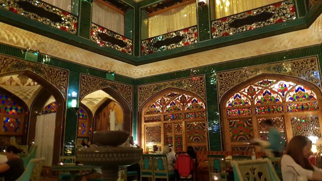 Carved wooden balconies and arches inside a Souq Waqif hotel.