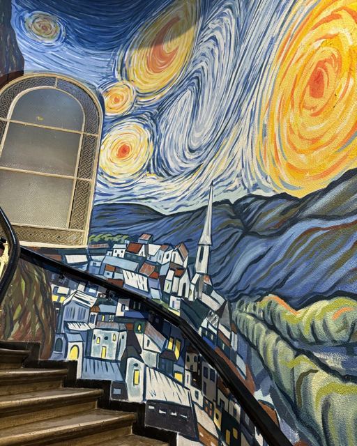 Staircase wall painted with a large swirling mural in the style of Van Gogh's Starry Night.