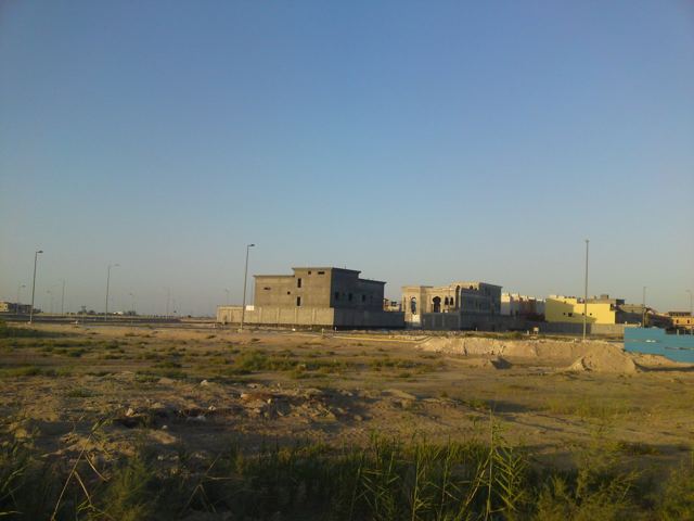 Flat open ground and low buildings stretching to the horizon in Al Khobar.