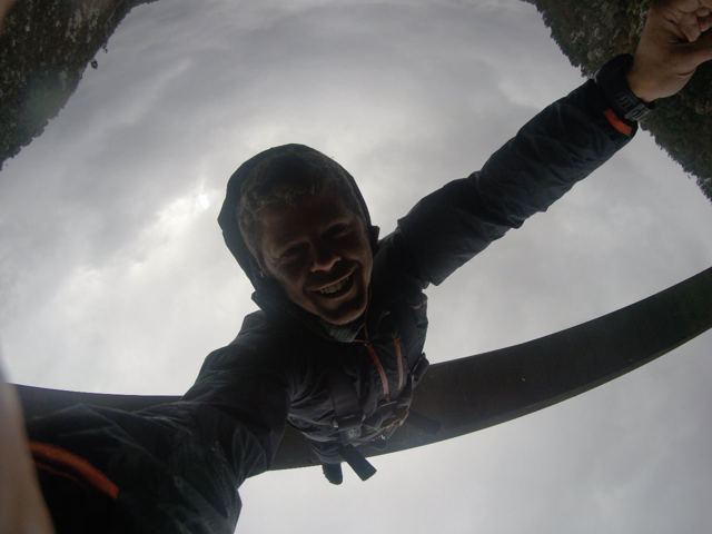 A man hanging upside down on a bungee cord beneath the arch of Bloukrans Bridge.