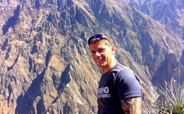 A smiling man in sunglasses in front of the steep terraced walls of Colca Canyon.