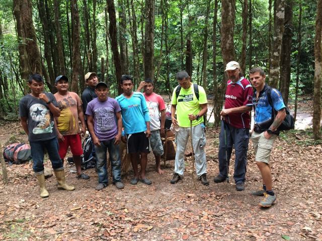 A group of hikers and local guides standing together in the jungle.