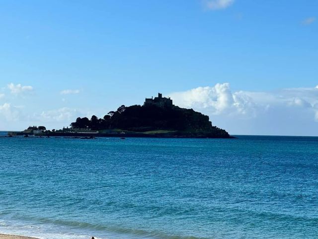 St Michael's Mount rising out of a calm blue sea.