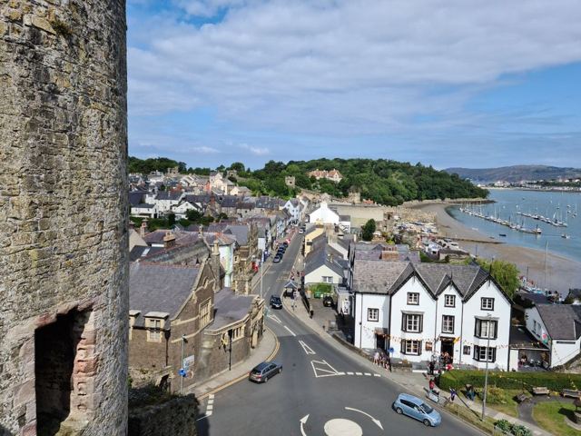 View from medieval stone walls over Conwy streets and rooftops towards the estuary.