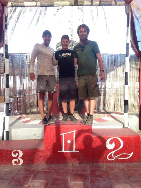 Three men posing on a red winners' podium in Namibia.