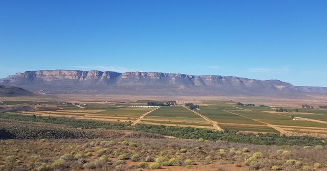A long flat-topped mountain above patchwork farmland and vineyards.